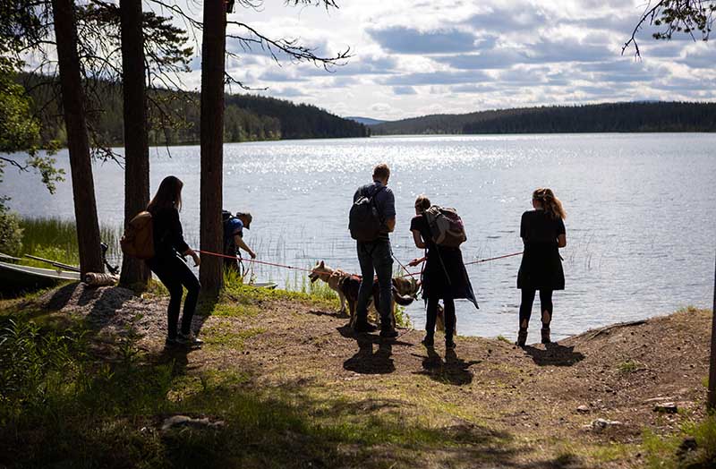 Die Teilnehmerinnen des Husky-Trails blicken auf einen See