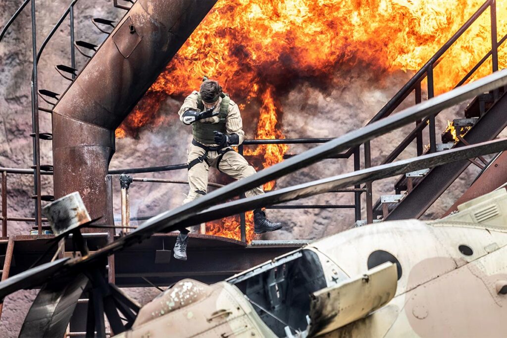 Patrick Richter schwebt in der Luft, hinter ihm eine Feuerwand