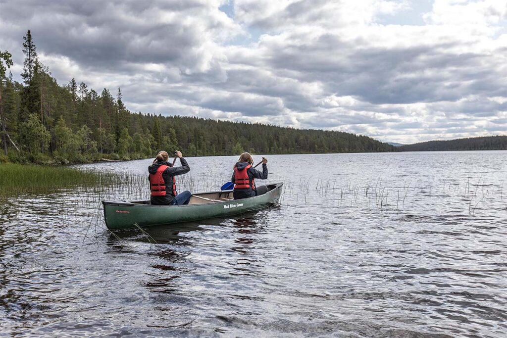 Anna und Judith paddeln im Kanu über einen Fluss