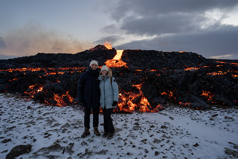 Mathias und Annika stehen Arm in Arm vor dem glühenden Vulkan