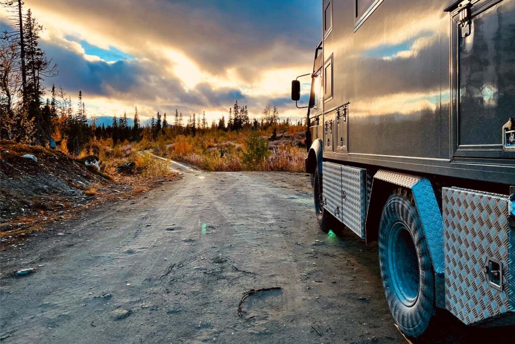 Das Löschfahrzeug auf einer geschotterten Straße im Sonnenuntergang