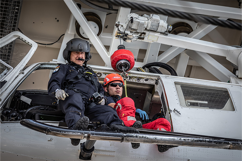 Hoist Operator und Feuerwehrmann an Helikopter